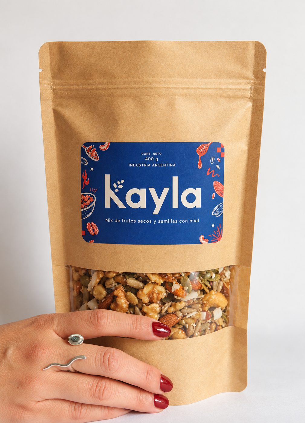 Mano sosteniendo una bolsa de papel kraft con etiqueta azul Kayla